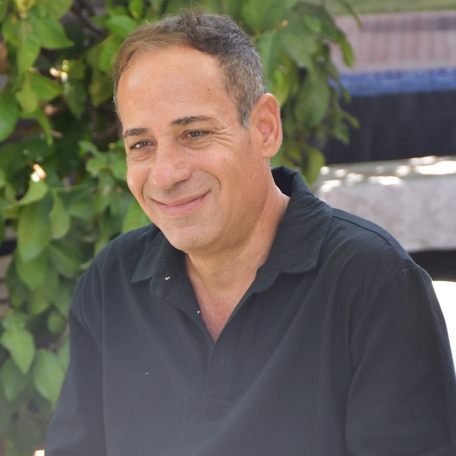 אלון שמש יושב בחצר הקליניקה, בין העצים